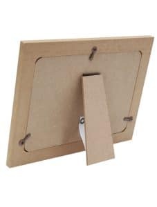 Achterzijde van het houten fotolijstje met standaard, gefotografeerd onder een lichte hoek. De lijst heeft een inklapbare steun waarmee hij stevig op een kast of plank geplaatst kan worden. Geen ophangsysteem aanwezig. Leverbaar in drie verschillende fotomaten: 10x15 cm, 13x18 cm en 15x20 cm.
