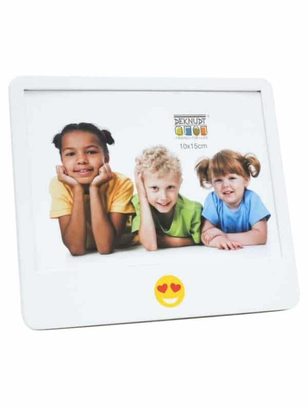 Vooraanzicht van een witte fotolijst van 10x15 cm met een vrolijke hartjes-emoji onderaan en een kleurrijke voorbeeldfoto van drie kinderen – perfect voor een persoonlijke en kindvriendelijke presentatie.