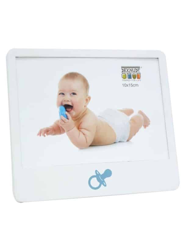 Witte fotolijst van Deknudt met een blauwe fopspeenillustratie onderaan en een voorbeeldfoto van een lachende baby in liggende houding.