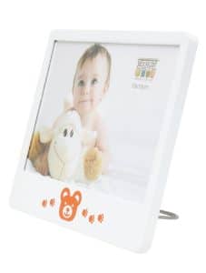 Schuin vooraanzicht van de witte Deknudt kinderlijst met beertjesdecor en een ingelijste babyfoto, op metalen standaard geplaatst.