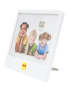 Witte fotolijst van 10x15 cm met hartjes-emoji aan de voorkant, schuin van voren gefotografeerd, met voorbeeldfoto van lachende kinderen – ideaal voor de kinderkamer of als speels cadeau.