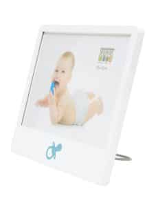 Schuin vooraanzicht van een witte babyfotolijst met blauwe fopspeenafbeelding en voorbeeldfoto van een baby met blauwe speen.